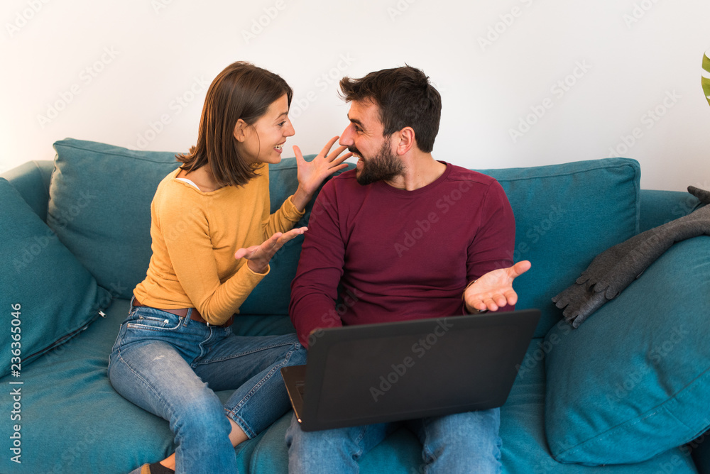 Φωτογραφία Happy smiling couple in love, surprised and excited sitting at home on couch using laptop
