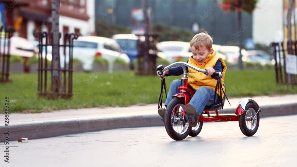 Happy child on red bike having fun outdoors. Active kid boy riding retro stylish bicycle. Cute smiling little boy playing and cycling on street road and spending family time. 4K video. Happy child on red bike having fun outdoors. Active kid boy riding retro stylish bicycle. Cute smiling little boy playing and cycling on street road and spending family time. 4K video.