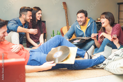 Sticker Group of happy friends doing party listening vintage vinyl disc at home - Young