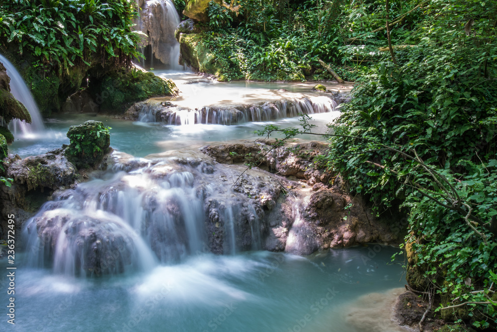 Beautiful stream waterfalls cascade over pretty green moss covered stones Beautiful stream waterfalls cascade over pretty green moss covered stones