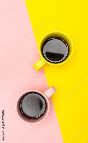 Flat lay of a two coffee cups with pink and yellow