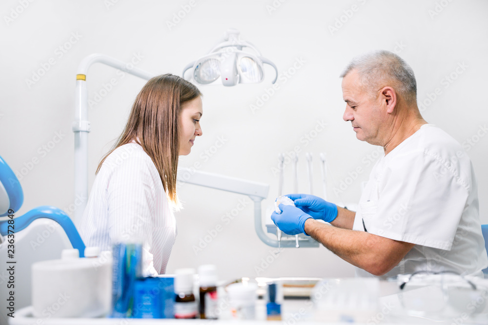 Dentist showing the client the layout of the jaw while in the dental clinic Dentist showing the client the layout of the jaw while in the dental clinic