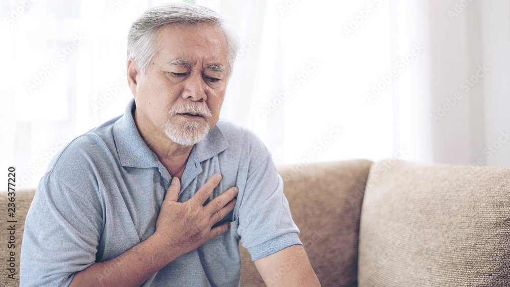 Senior male asian suffering from bad pain in his chest heart attack at home - senior heart disease Senior male asian suffering from bad pain in his chest heart attack at home - senior heart disease