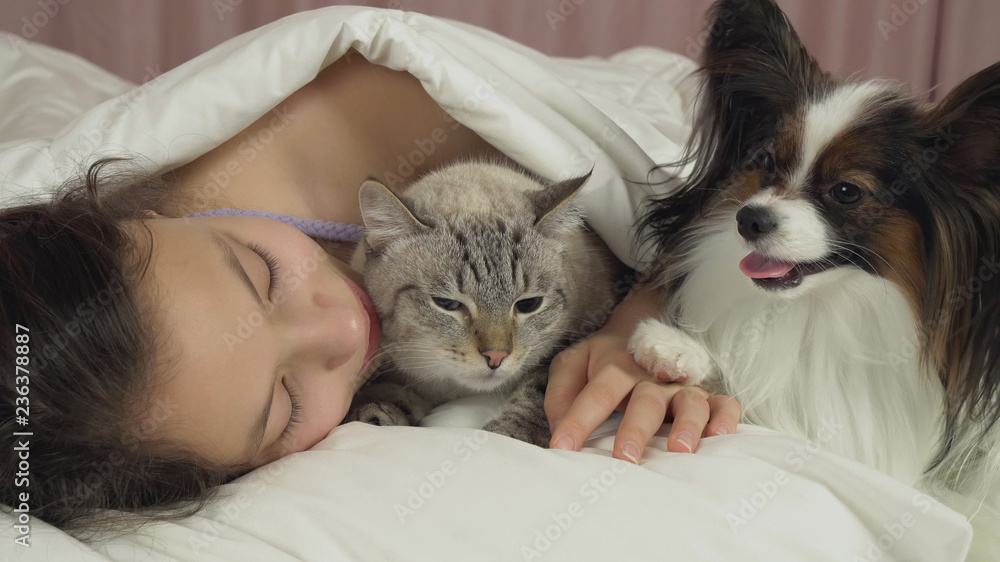 Beautiful teen girl sleeping sweetly in bed with dog and cat Beautiful teen girl sleeping sweetly in bed with dog and cat