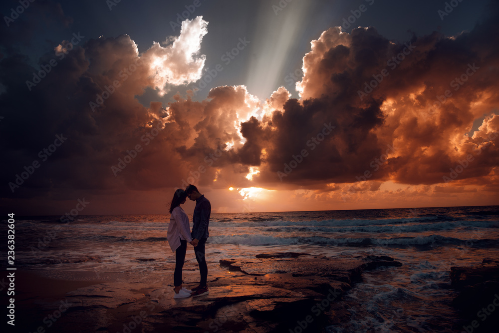 Couple in love at a fiery sunset.Silhouette photo - obrazy, fototapety, plakaty 