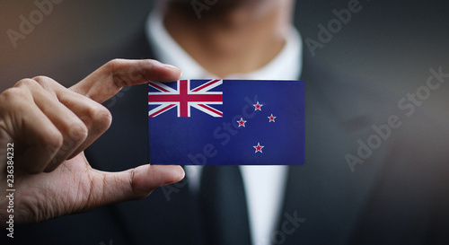 Businessman Holding Card of New Zealand Flag