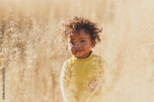 Happy boy child is smiling enjoying adopted life. Portrait of young boy in nature, park or outdoors. Concept of happy family or successful adoption or parenting. photo