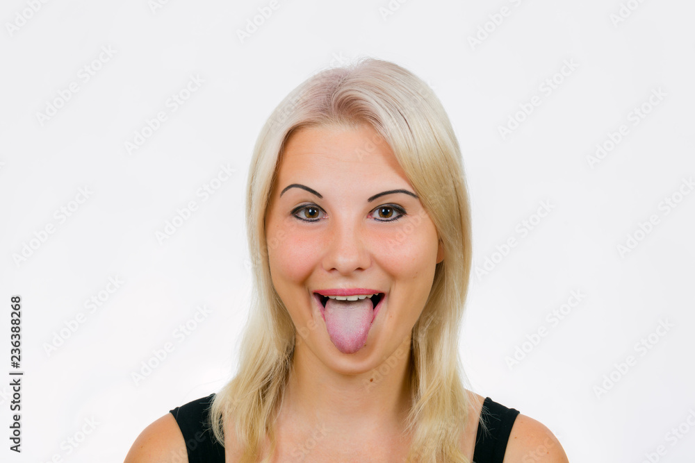 Fototapeta premium Female face with tongue out close-up
