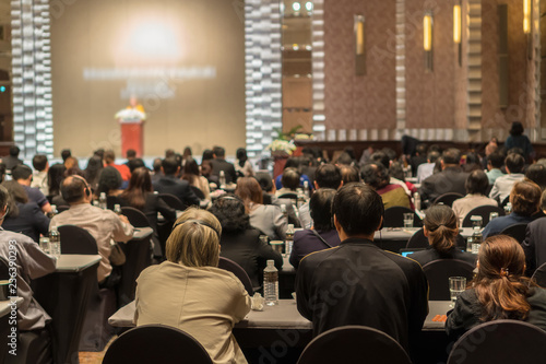 Rear view of Audience wearing and listening Speakers via Interpreter Headset on the stage in the conference hall or seminar meeting, business and education about investment concept