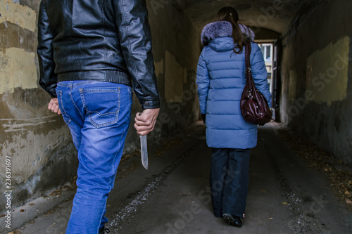 Unknown criminal guy with knife chasing young girl