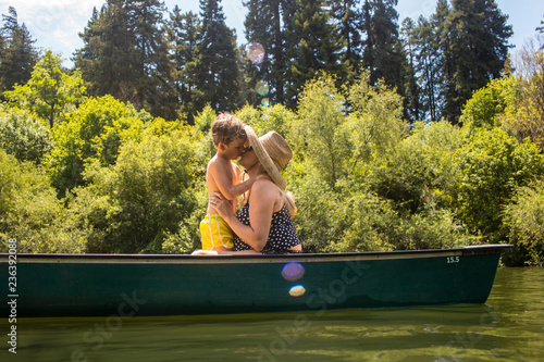 Mother kissing son in canoe