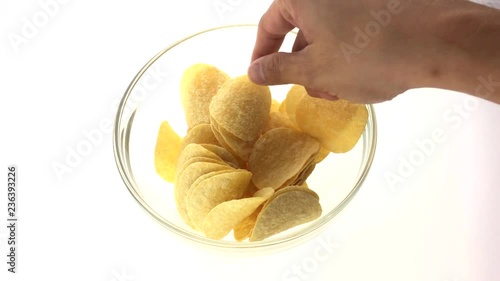 Time lapse of Hand taking crisps from glass bowl, top view