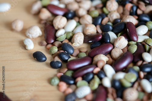 Mix of different beans on wooden background close up
