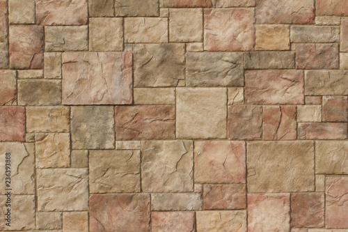 Textured marble look stone wall abstract background in shades of tan, brown and red