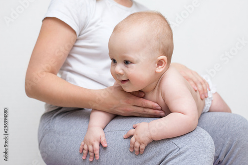 mother and her baby doing exercises on a ball