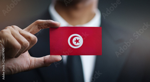 Businessman Holding Card of Tunisia Flag photo