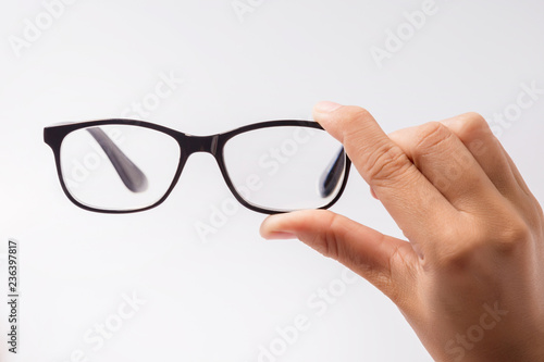 Woman holding the black eye glasses spectacles with shiny black frame isolated on white