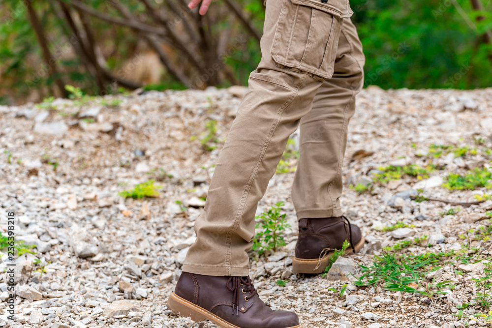 Man wearing cargo pants and climbing on the rock Man wearing cargo pants and climbing on the rock