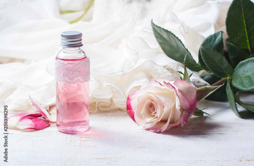 perfumed rose water in a bottle on a wooden table perfumed rose water in a bottle on a wooden table