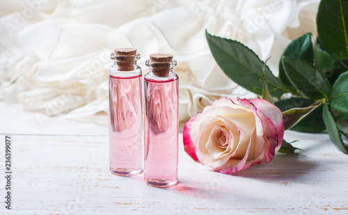 perfumed rose water in a bottle on a wooden table