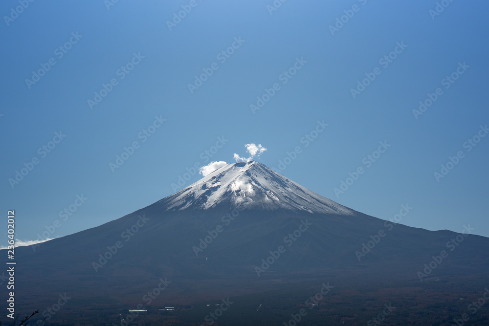 Fuji mountain in Japan with snow cover on the top with could and little fog or mist at morning
