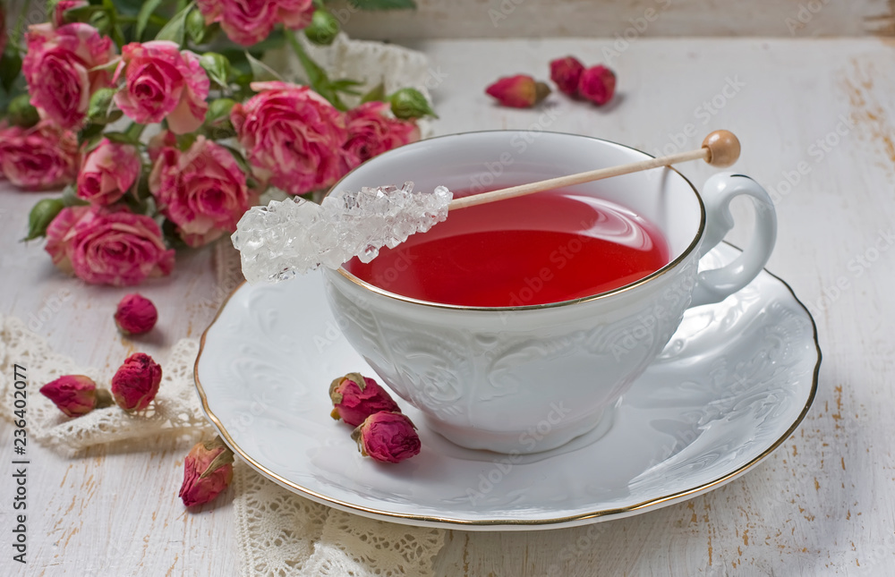 Cup of tea with dried rose buds and fresh roses Cup of tea with dried rose buds and fresh roses