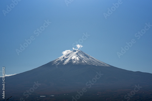Fuji mountain in Japan with snow cover on the top with could and little fog or mist at morning