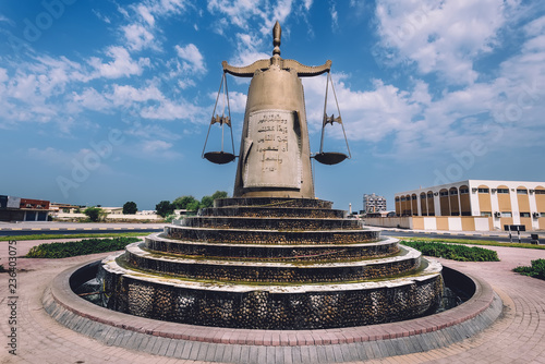 September 8, 2017 - Ras al Khaimah, United Arab Emirates. Roundabout With Scales Of Justice Statue and waterfall In Ras Al Khaimah Emirate in UAE. Traffic island with landmark on local road. photo