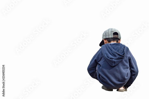 Isolated Asian boy wearing a winter jacket and hat sitting on a white background with clipping path.