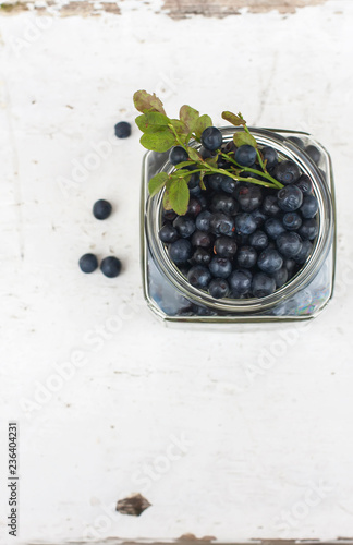 Fresh blueberries in a bowl, on a wooden table.