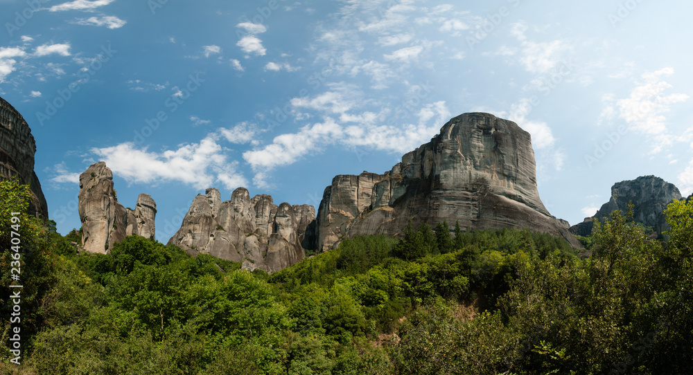 Rocks in Meteora region with blue sky and white clouds - famous place with monasteries on tops, UNESCO World Heritage, Greece. Panoramic photo. Rocks in Meteora region with blue sky and white clouds - famous place with monasteries on tops, UNESCO World Heritage, Greece. Panoramic photo.