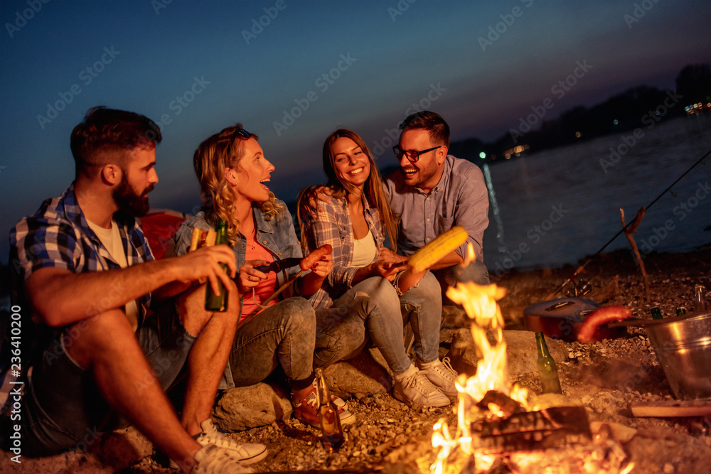 Friends having picnic around the fire