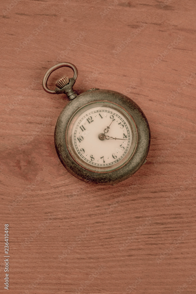 An old watch, shot from the top on a dark rustic wooden background with a place for text, toned image An old watch, shot from the top on a dark rustic wooden background with a place for text, toned image