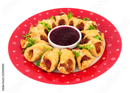 Savoury pigs in blankets with cranberry sauce dip isolated on a white background