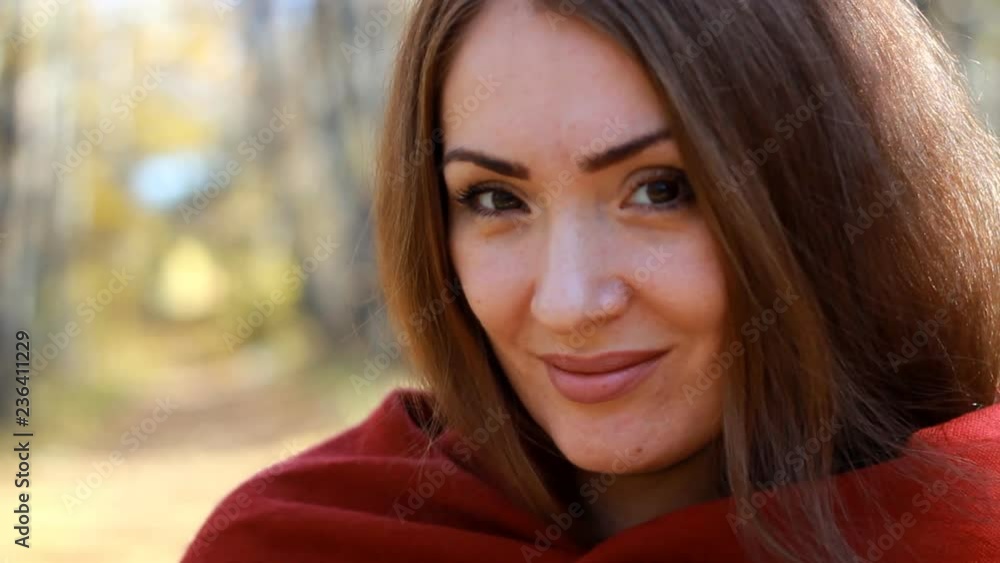 Portrait of a close-up woman who dresses a blanket. Cold weather on a sunny autumn day Portrait of a close-up woman who dresses a blanket. Cold weather on a sunny autumn day