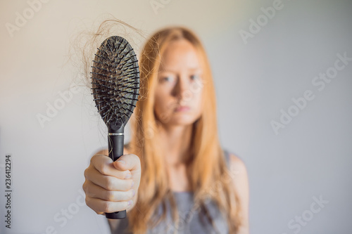 Hair loss in women concept. A lot of lost hair on the comb photo