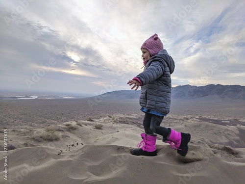 A little girl walking over cold sand