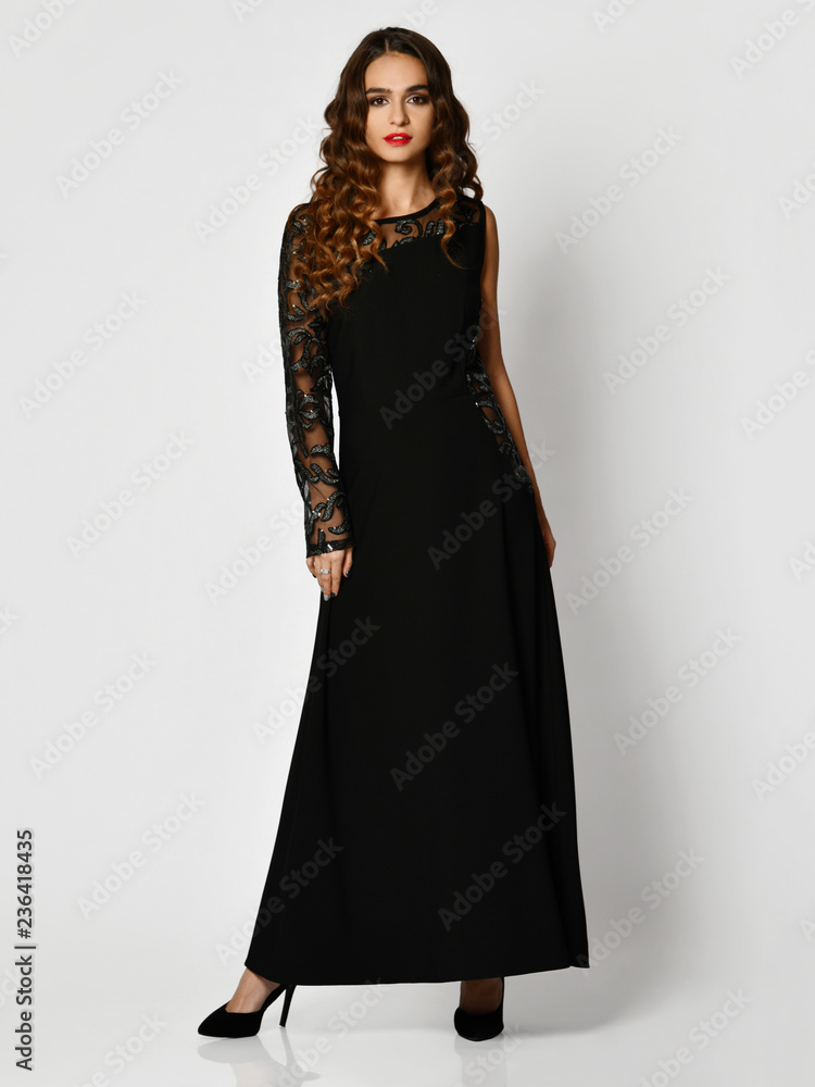 Young beautiful woman posing in new black fashion winter dress full body on a white Young beautiful woman posing in new black fashion winter dress full body on a white