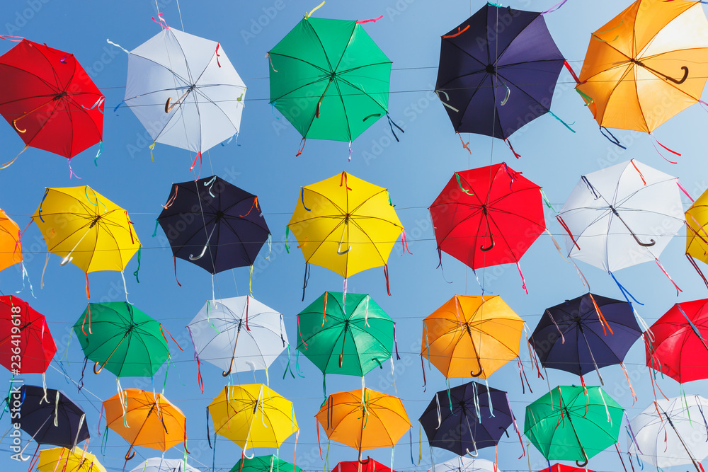 Colored umbrellas hanging above the street, soft focus background Colored umbrellas hanging above the street, soft focus background