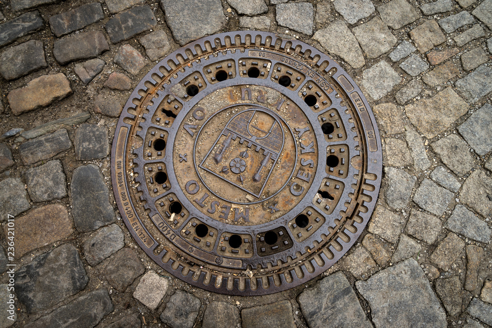 The metal plate drain hose on the stone road in Cesky Krumlov, Czech The metal plate drain hose on the stone road in Cesky Krumlov, Czech
