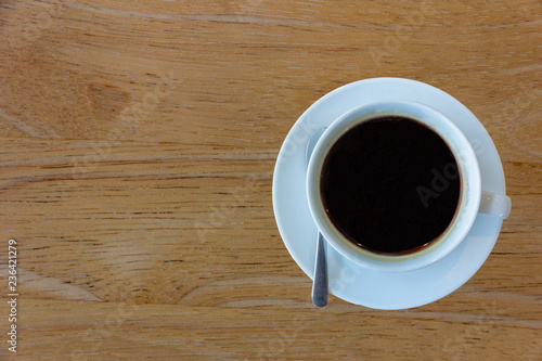 Top view a cup of black coffee on old warm wooden background