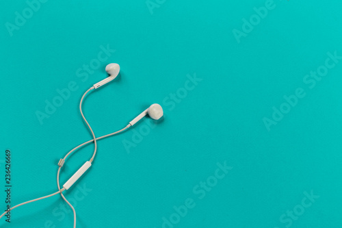 White earphones on colour background