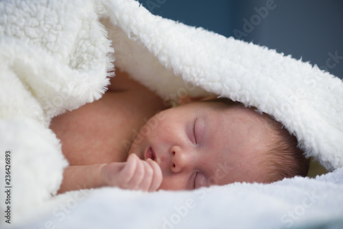 Newborn baby boy portrait on white carpet closeup. Motherhood and new life concept