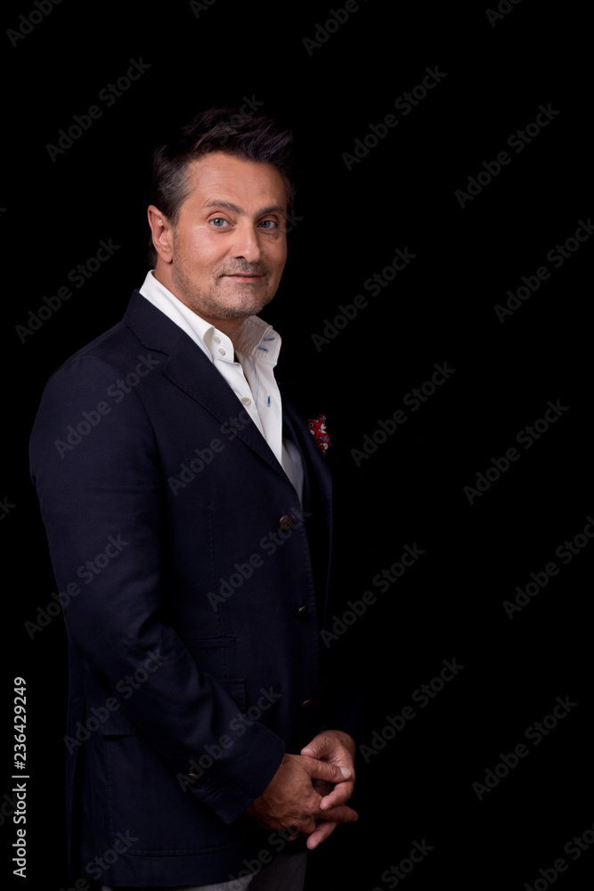 Waist up of the elegant man standing against the black background Waist up of the elegant man standing against the black background