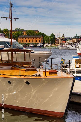 Photography Yacht moored to a pier with harbor and stockholm cityscape on background