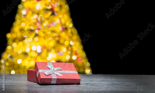 Prezent pod choinką. Prezent Bożonarodzeniowy. Tło świąteczne. Pudełko prezentowe na tle choinki. Miejsce na napis, życzenia. 