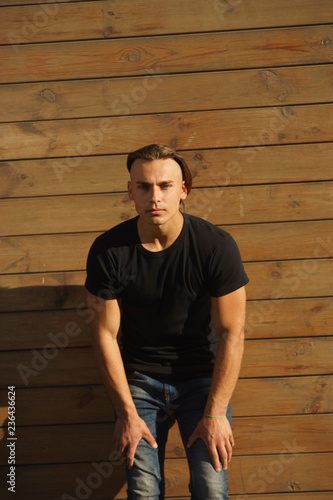 portrait of young man in front of wooden wall