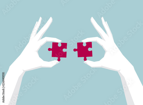 Fototapeta Naklejka Na Ścianę i Meble -  Two hands holding puzzle, hand is white.