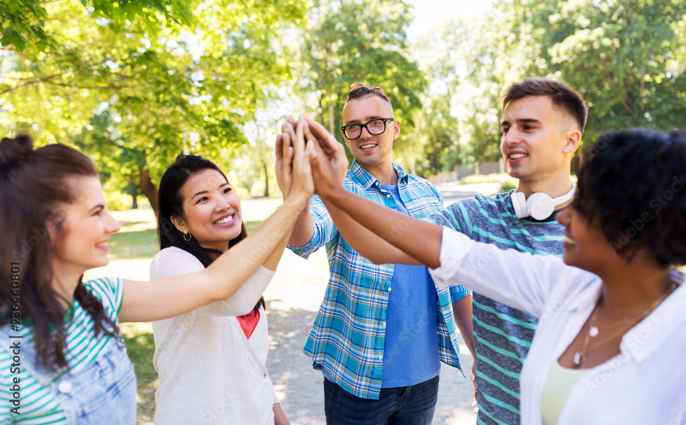 success, friendship and international concept - group of happy smiling friends making high five in park success, friendship and international concept - group of happy smiling friends making high five in park