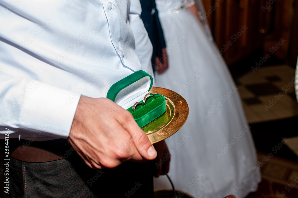 groom holding wedding rings in the green box groom holding wedding rings in the green box